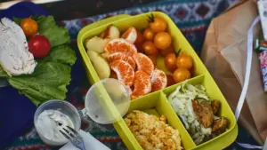 Daudzveidīga un veselīga bērnu pusdienu kārbiņa ar augļiem, dārzeņiem un svaigiem pārtikas produktiem.